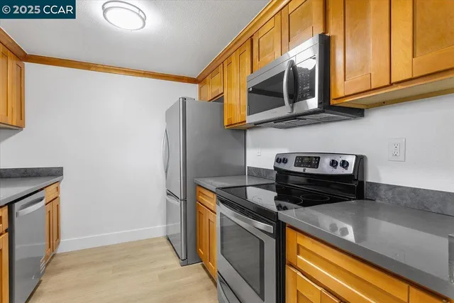 a kitchen with stainless steel appliances granite countertop a refrigerator and a stove top oven