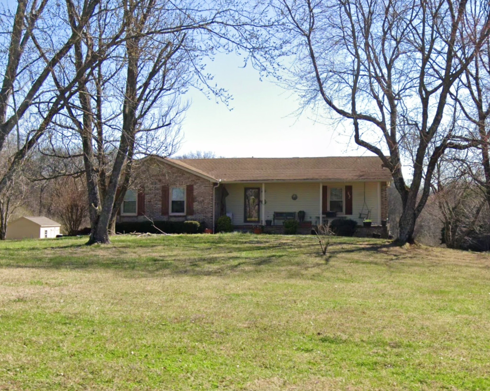 a brick house with trees in front of it
