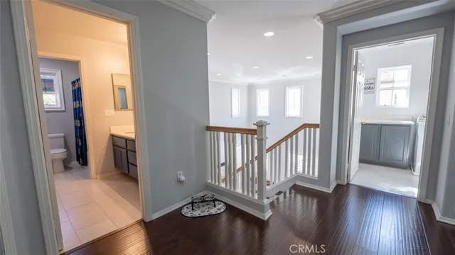 a bedroom with a bed television on desk and a window