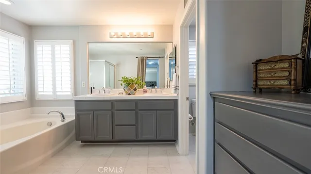 a bedroom with a large bed and a flat tv screen on a dresser