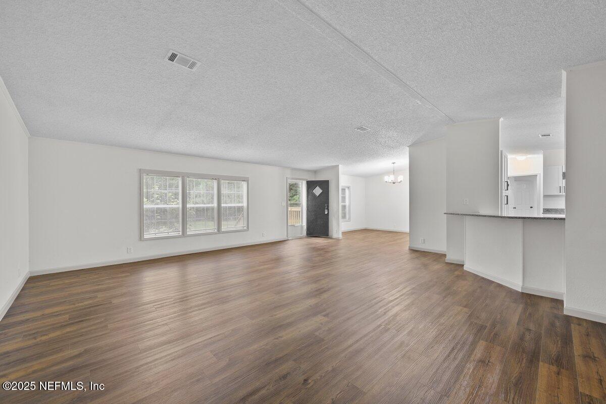 54003 Plantation Road Callahan, FL 32011 - Photo 4 of 29 a view of an empty room with wooden floor and a window