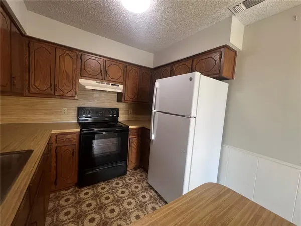 a kitchen with a refrigerator stove and cabinets