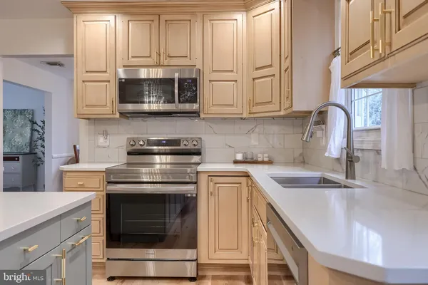 a kitchen with stainless steel appliances granite countertop a sink stove and microwave