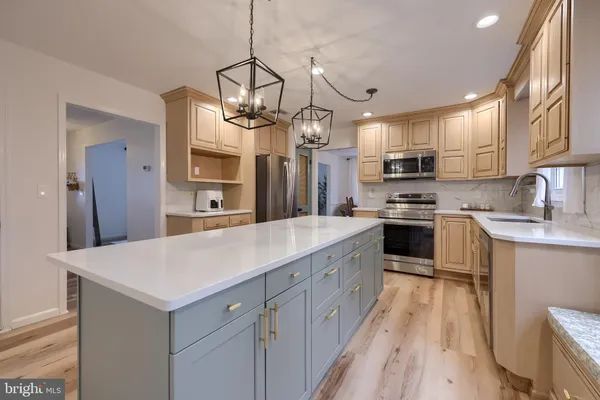 a kitchen with kitchen island white cabinets and stainless steel appliances
