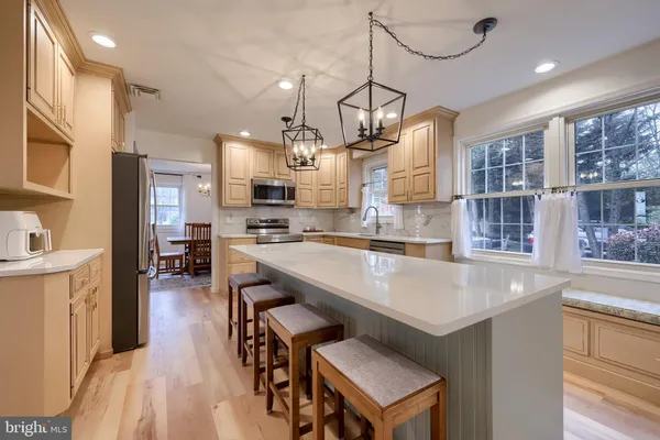 a kitchen with kitchen island white cabinets and stainless steel appliances