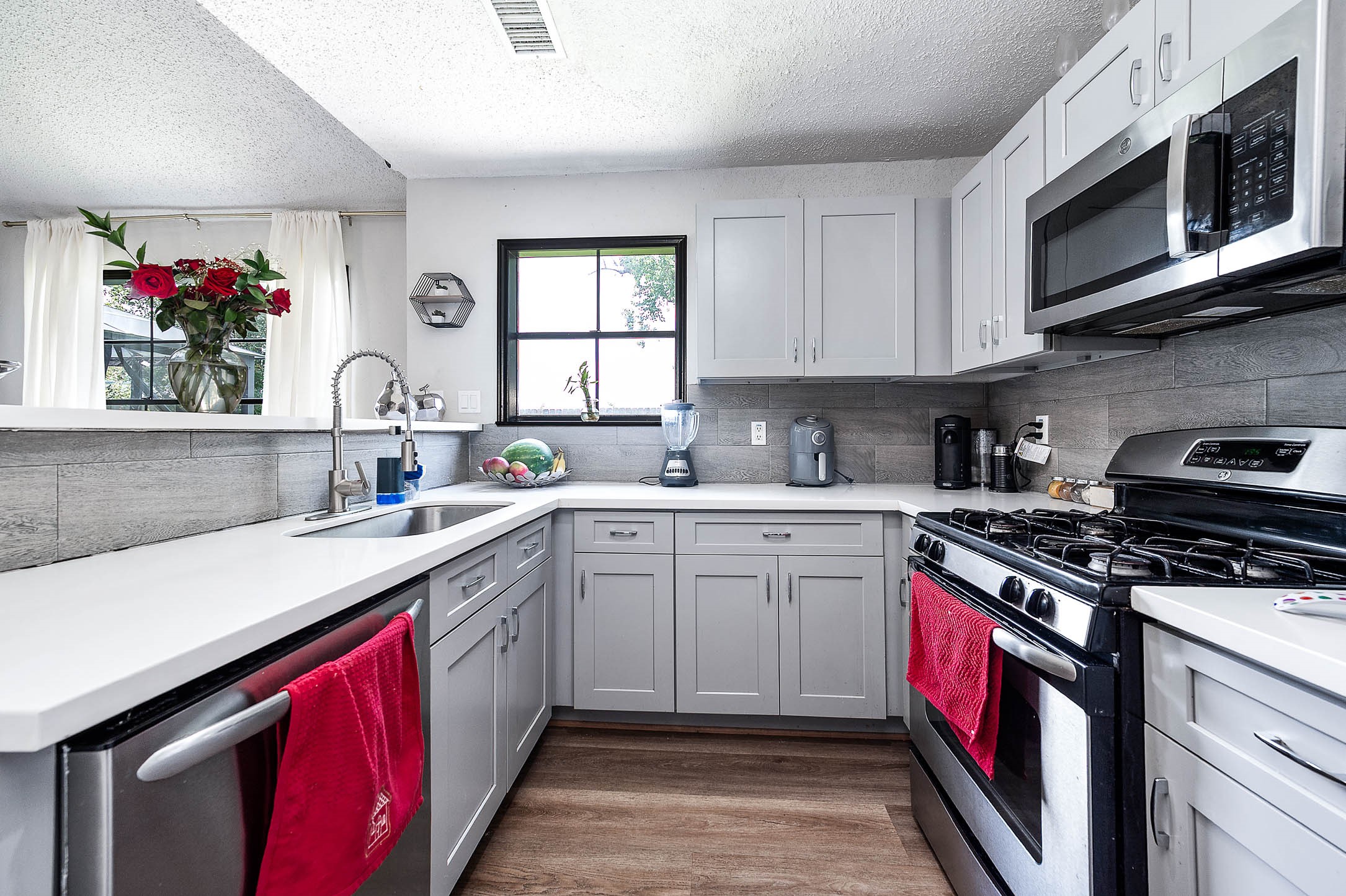 18446 North Willow Bluff Road Katy, TX 77449 - Photo 12 of 31 a kitchen with stainless steel appliances granite countertop a sink dishwasher stove and microwave with wooden cabinets