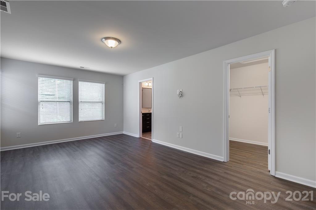 1556 Spring Blossom Trail Fort Mill, SC 29708 - Photo 14 of 22 an empty room with wooden floor and windows