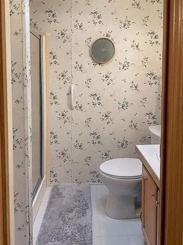 a bathroom with a granite countertop sink and a toilet