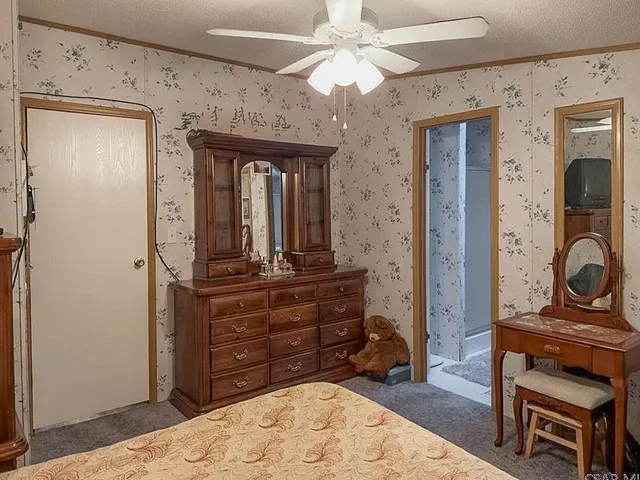 a bed sitting in a bedroom next to a wooden cabinet
