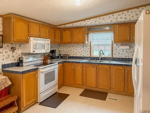 a kitchen with stainless steel appliances granite countertop a sink stove and cabinets