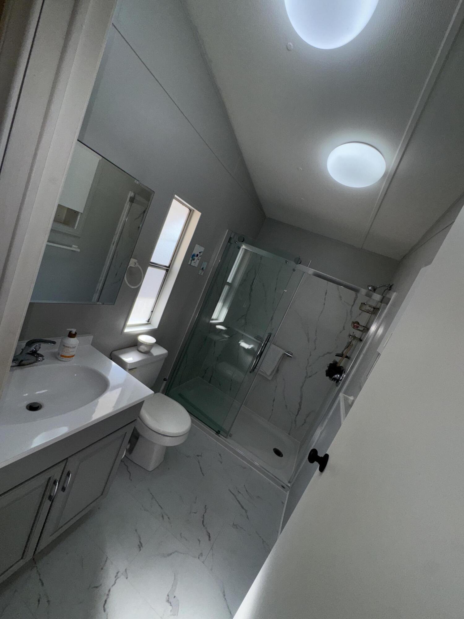 46618 Madison Street, Unit 153 Indio, CA 92201 - Photo 11 of 14 a bathroom with a toilet sink and mirror