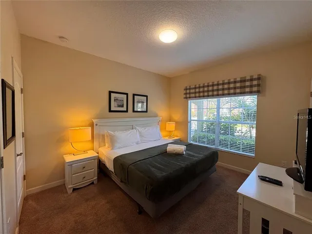 a bedroom with a bed and large window