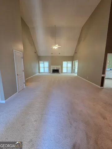 a view of an empty room with windows and fireplace