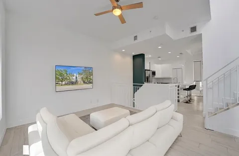 a living room with furniture and kitchen view