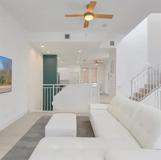 a large white bedroom with a large bed and chandelier