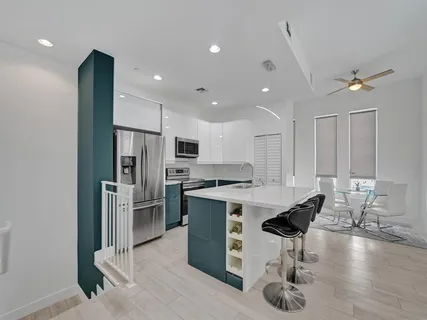 a kitchen with stainless steel appliances kitchen island granite countertop a stove refrigerator and cabinets