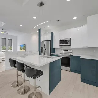 a kitchen with stainless steel appliances kitchen island granite countertop a stove a sink a microwave a dining table and chairs