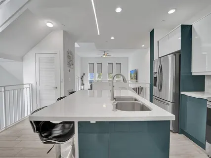 a kitchen with stainless steel appliances a sink a table and chairs
