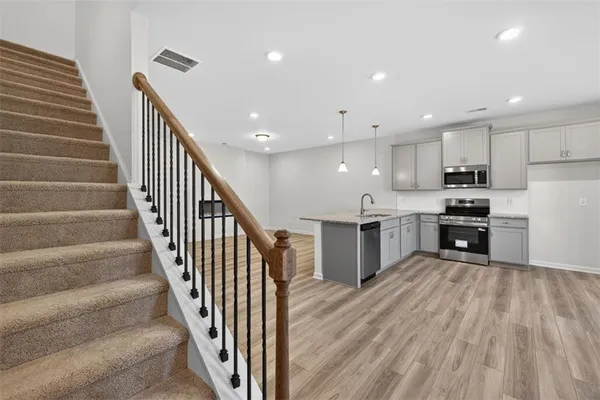 a view of kitchen with wooden floor and electronic appliances