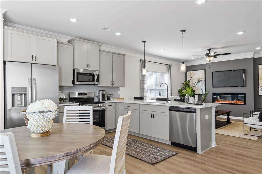 312 Caroline Place, Unit 99 Villa Rica, GA 30180 - Photo 16 of 24 a kitchen with stainless steel appliances granite countertop a stove top oven a sink a dining table and chairs