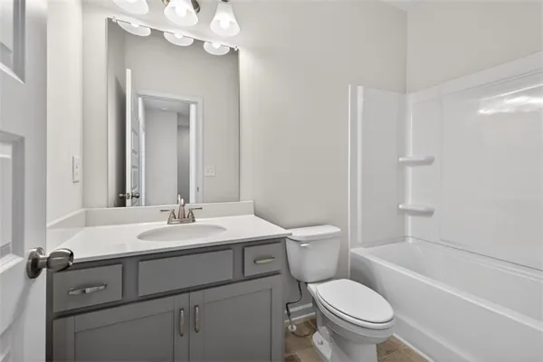 a bathroom with a toilet a sink a tub and mirror