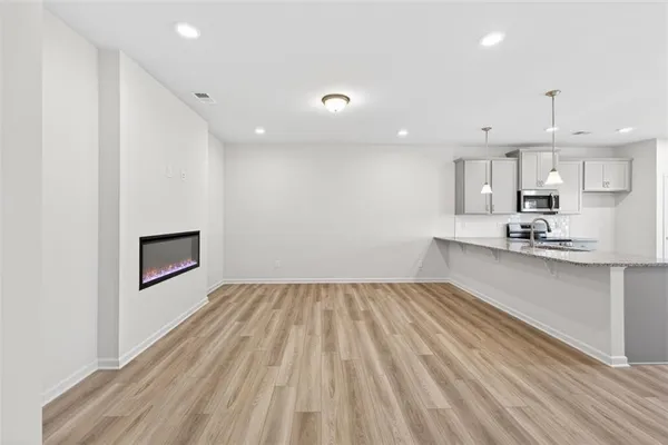 a view of kitchen with granite countertop cabinets and wooden floor