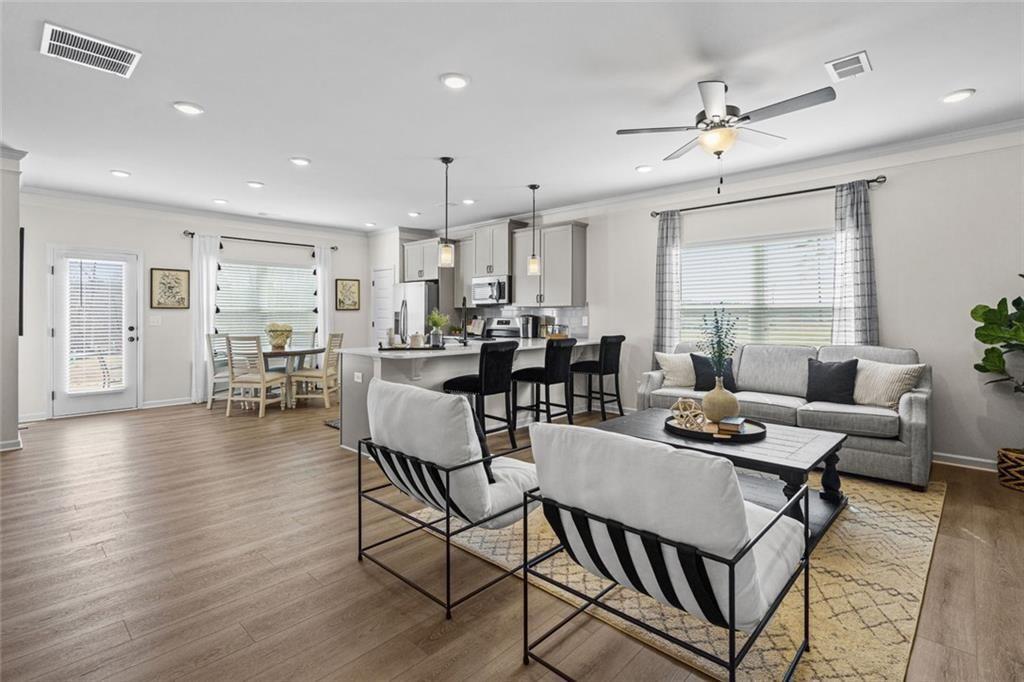 312 Caroline Place, Unit 99 Villa Rica, GA 30180 - Photo 5 of 24 a dining room with wooden floor a glass table and chairs