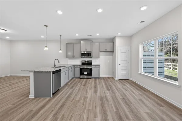 a large kitchen with stainless steel appliances granite countertop a stove a sink and a refrigerator