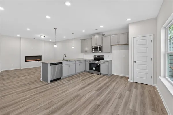 a kitchen with stainless steel appliances kitchen island granite countertop a stove a sink and a refrigerator