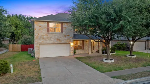 a front view of a house with a yard and tree s