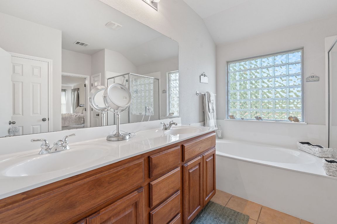 1024 Portchester Castle Path Pflugerville, TX 78660 - Photo 17 of 40 Full bath with a shower stall, light tile patterned floors, a garden tub, and healthy amount of natural light