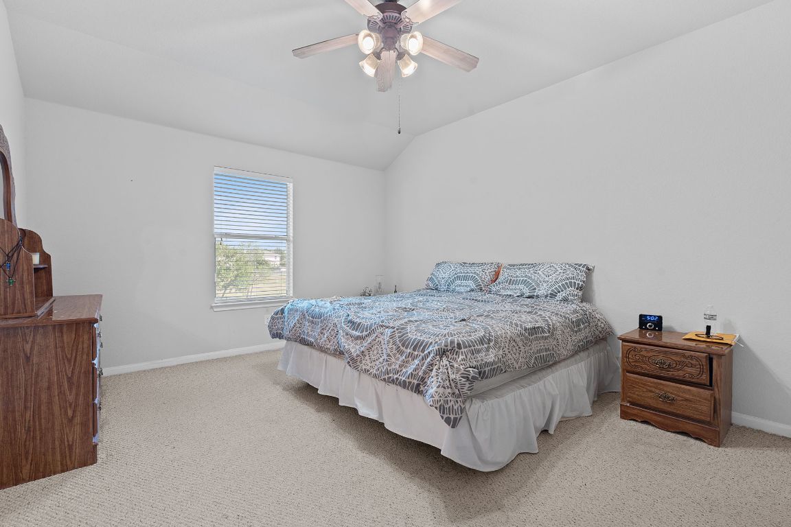 1024 Portchester Castle Path Pflugerville, TX 78660 - Photo 19 of 40 Bedroom featuring light colored carpet, lofted ceiling, and ceiling fan