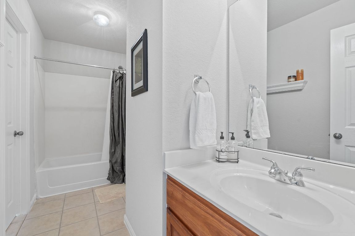 1024 Portchester Castle Path Pflugerville, TX 78660 - Photo 20 of 40 Full bath with light tile patterned floors, shower / bath combo with shower curtain, and vanity