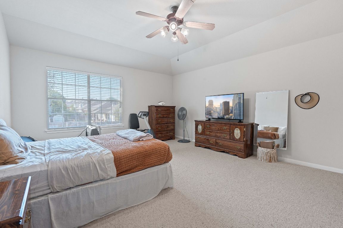 1024 Portchester Castle Path Pflugerville, TX 78660 - Photo 21 of 40 Bedroom featuring carpet flooring, a ceiling fan, and vaulted ceiling