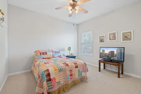 a bedroom with a bed and a lamp on a dresser