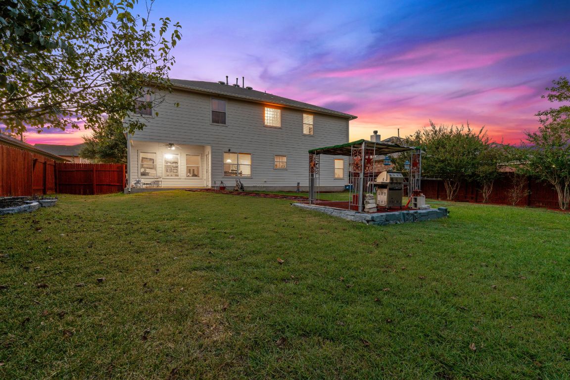 1024 Portchester Castle Path Pflugerville, TX 78660 - Photo 38 of 40 Back of house at dusk featuring a fenced backyard