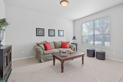 a living room with furniture a window and a table