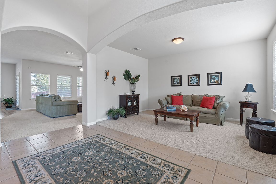 1024 Portchester Castle Path Pflugerville, TX 78660 - Photo 7 of 40 Living area featuring light carpet, arched walkways, light tile patterned floors, and ceiling fan