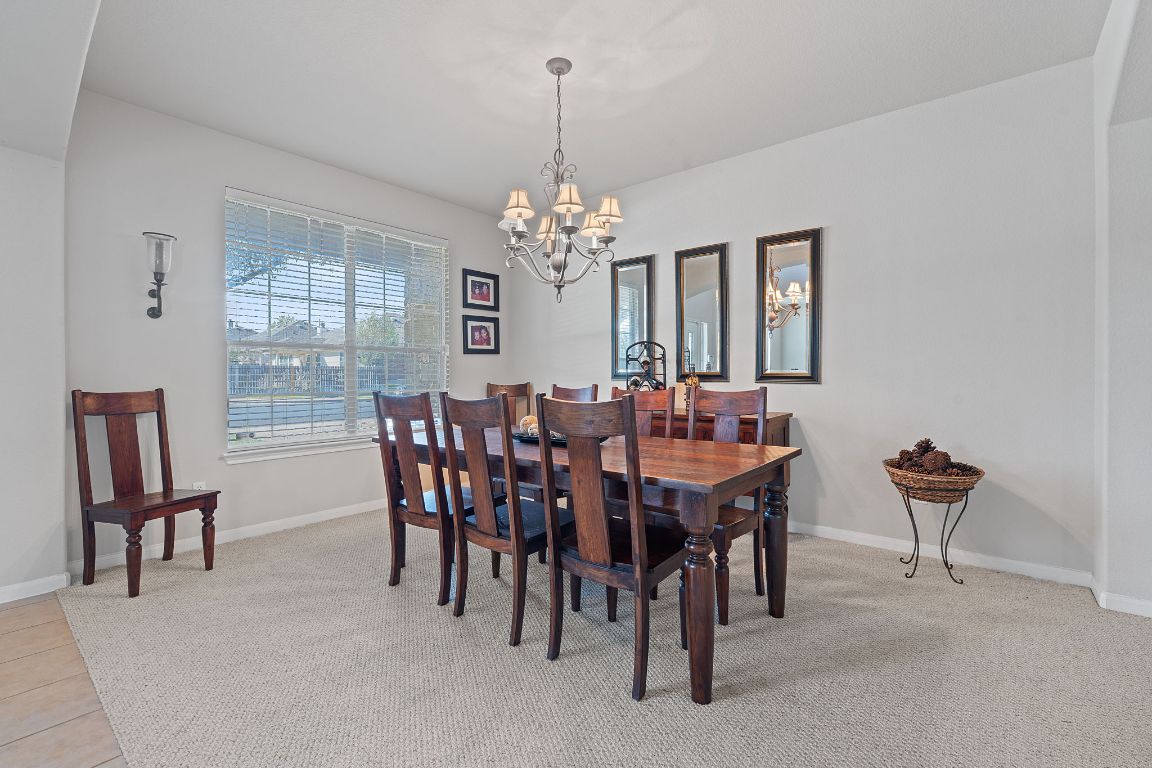 1024 Portchester Castle Path Pflugerville, TX 78660 - Photo 8 of 40 Dining space featuring a chandelier and light colored carpet