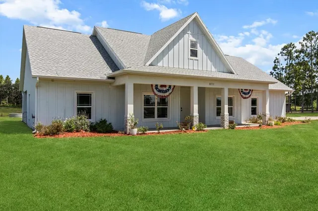 a front view of a house with a garden and yard