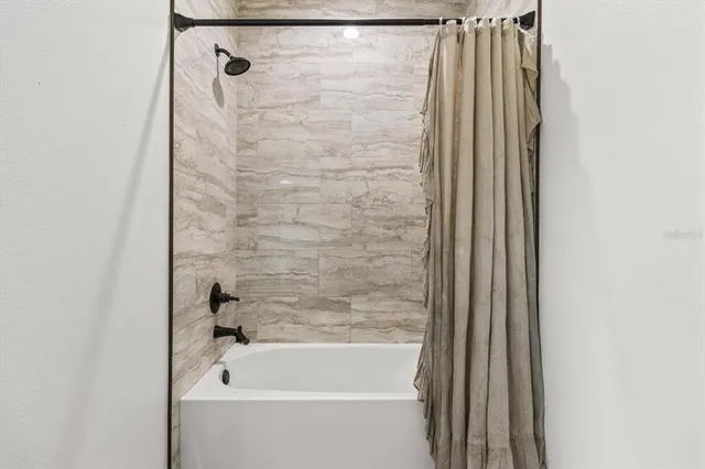 a bathroom with a shower and a bath tub