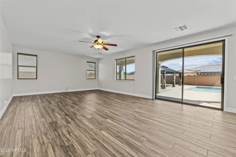 a view of an empty room with a window and wooden floor