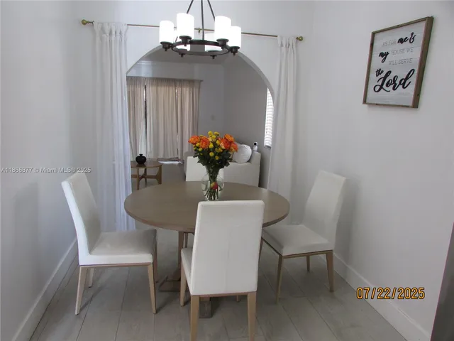 a view of a dining room with furniture wooden floor and a chandelier