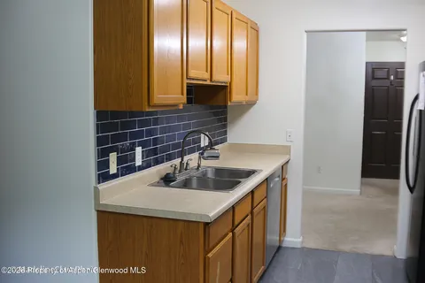 a kitchen with stainless steel appliances granite countertop a sink and a refrigerator
