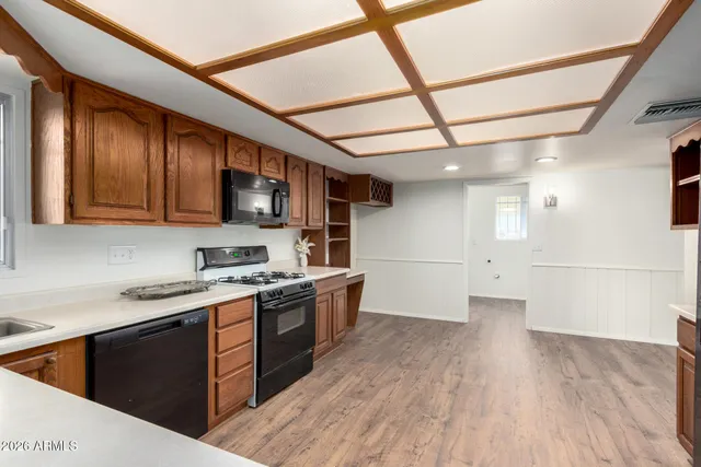 a kitchen with stainless steel appliances granite countertop a sink a stove a refrigerator cabinets and wooden floor