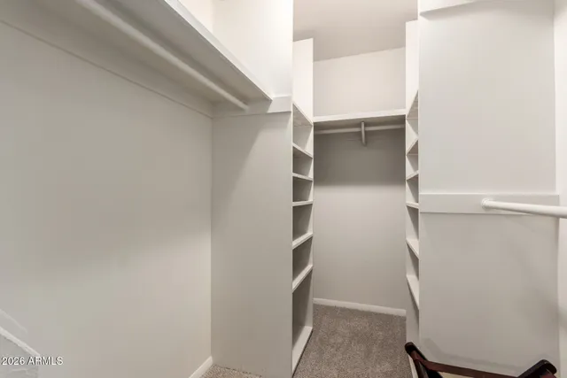 a view of walk in closet with empty racks