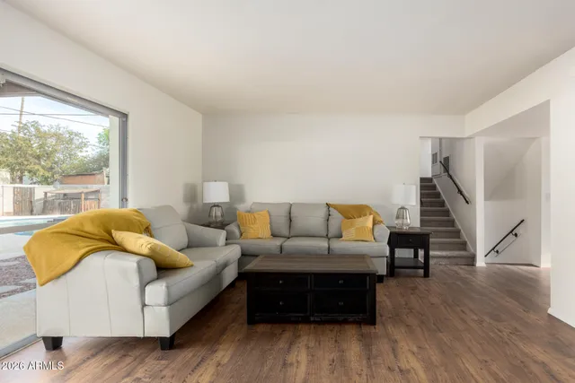 a living room with furniture and a wooden floor