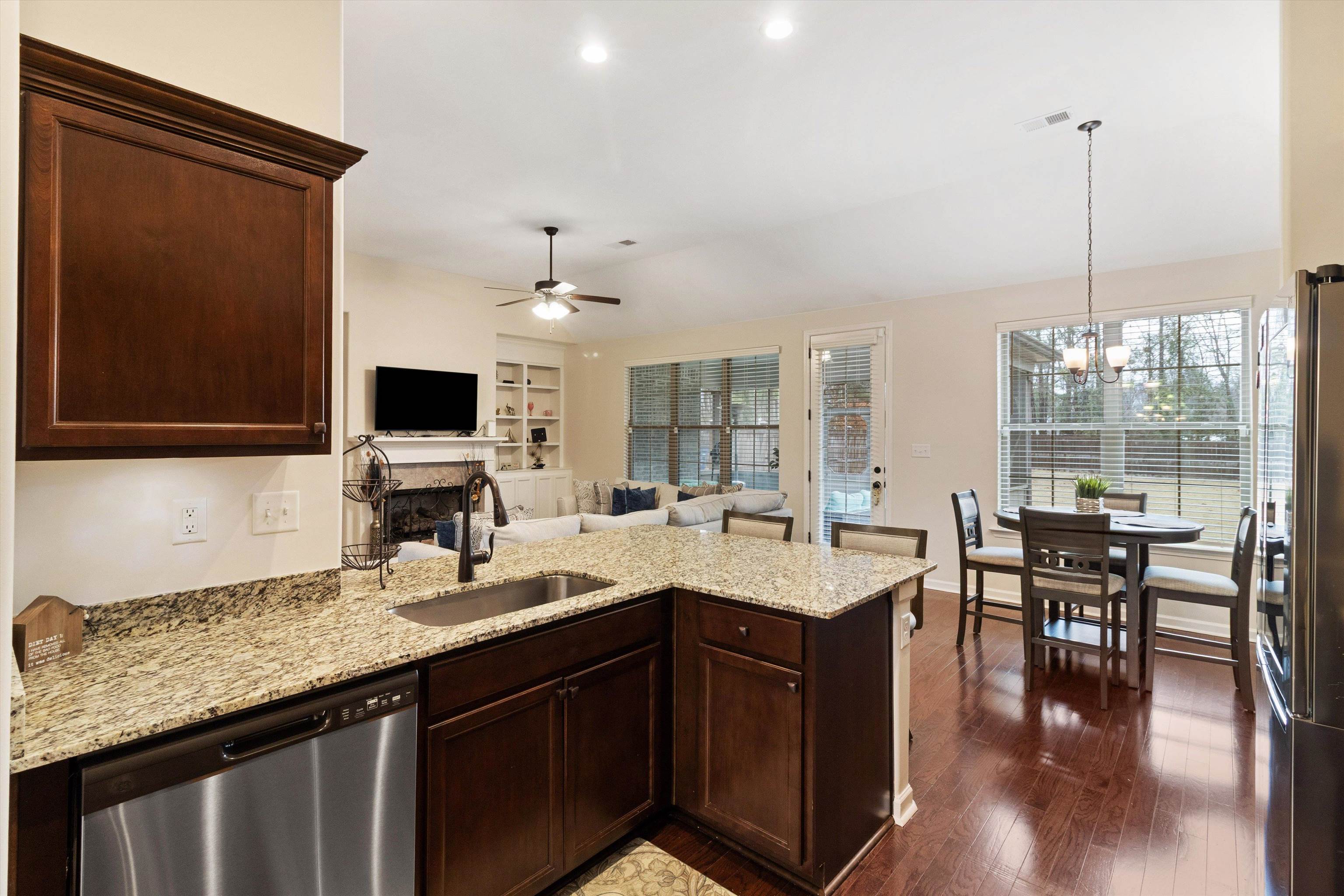 5504 Stonecrest Drive Olive Branch, MS 38654 - Photo 16 of 19 Kitchen with a peninsula, light stone counters, dark brown cabinets, and stainless steel appliances