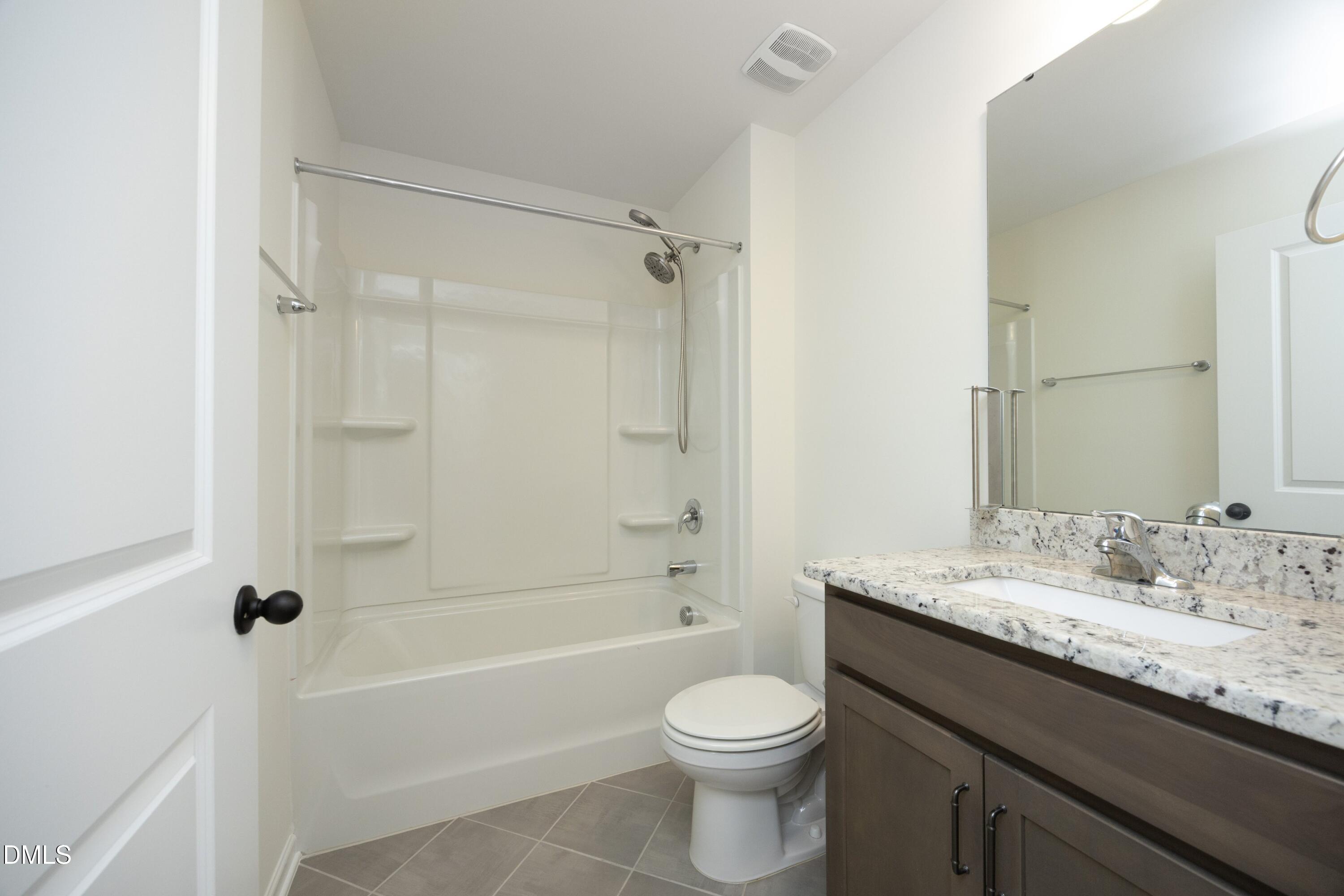 824 Country Downs Road Wake Forest, NC 27587 - Photo 30 of 41 a bathroom with a granite countertop sink a toilet and shower