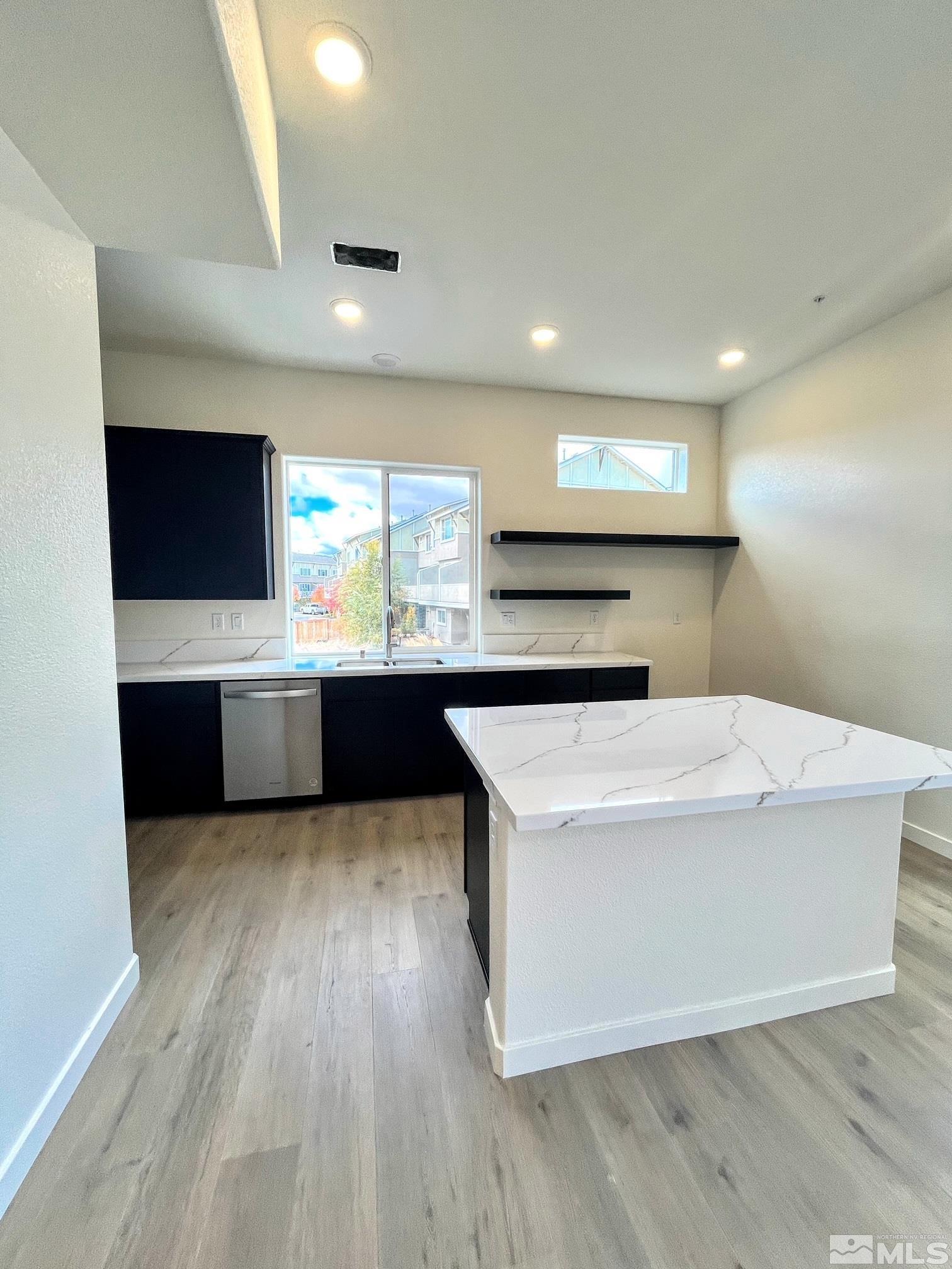 156 Rissone Lane, Unit LOT 33 Reno, NV 89503 - Photo 6 of 21 a large white kitchen with a large counter top and stainless steel appliances